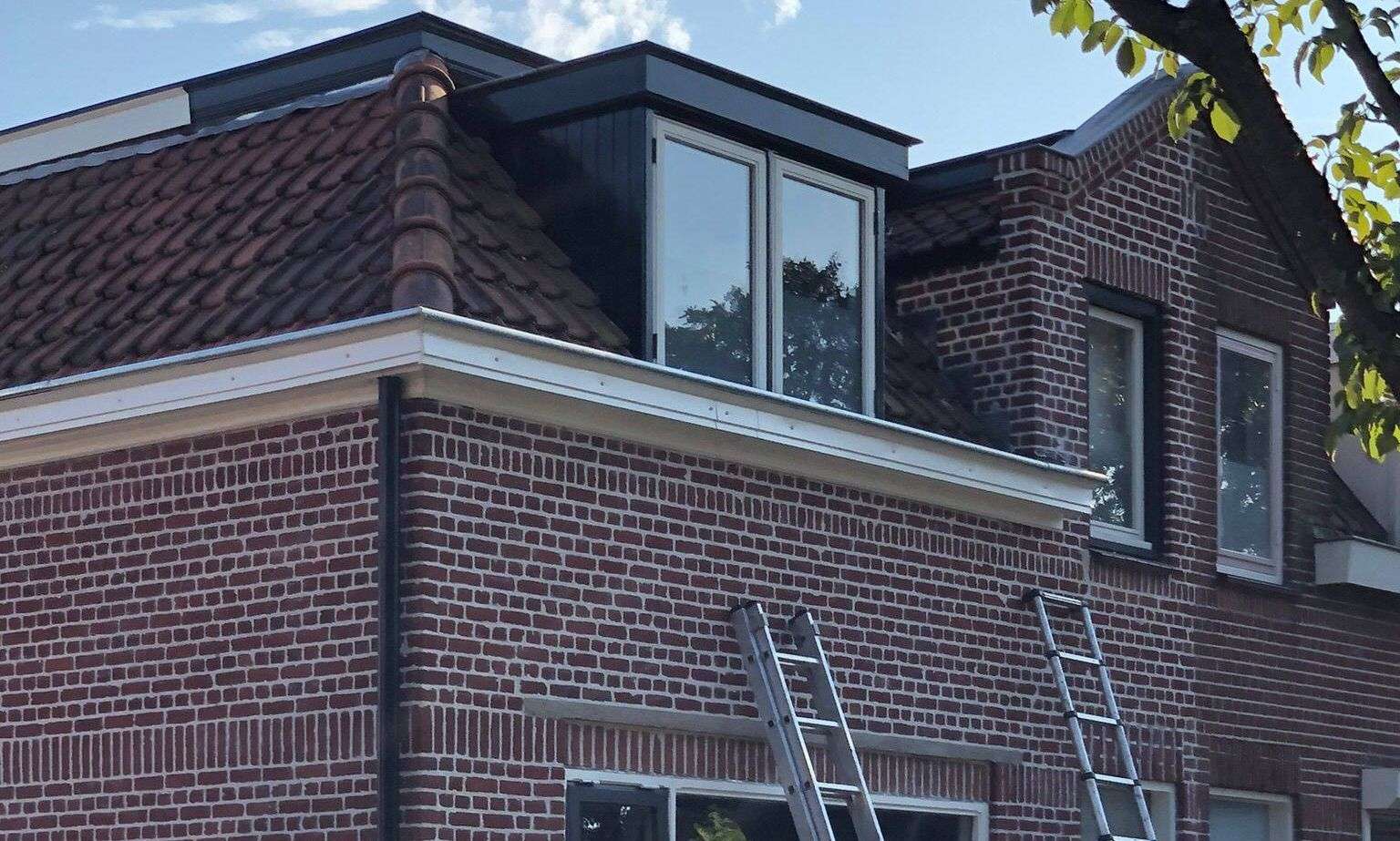 Met de ladden een dakgoot inspecteren in Berghem